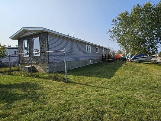 Purple mobile home with fenced yard.