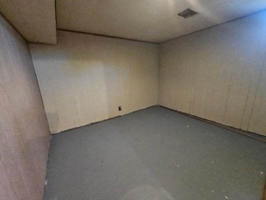 Empty basement room with gray floor.
