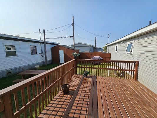 Wooden deck with backyard and houses.