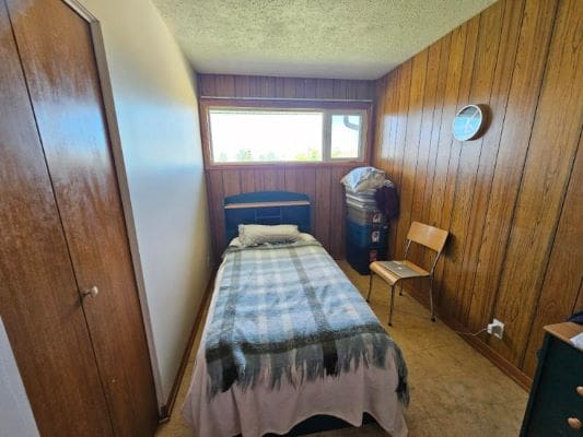 Small bedroom with single bed and window.