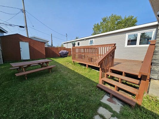 House backyard with deck and picnic table.