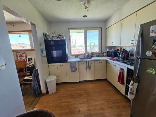 Kitchen with wood floor and appliances.