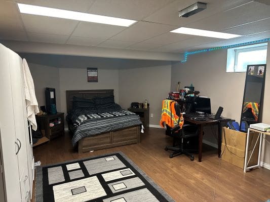 Basement bedroom with desk and computer.