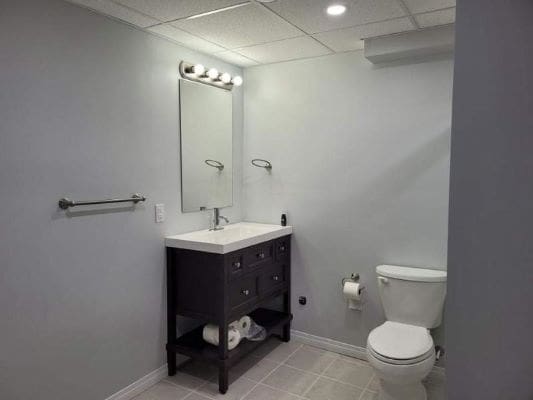 Basement bathroom with vanity and toilet.