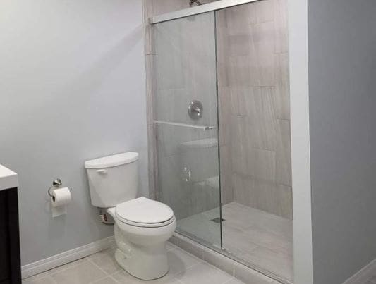 Toilet and shower in small bathroom.
