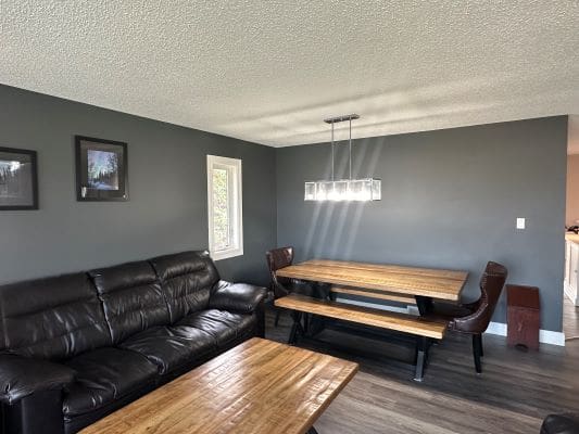 Dining room with leather sofa and wood table.