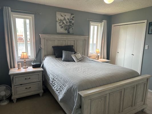 Light grey bedroom with queen bed.