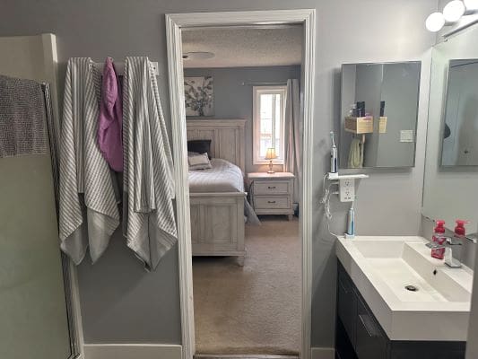 Bathroom with bedroom view and towels.
