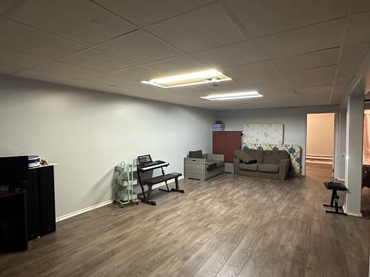 Spacious basement room with furniture.