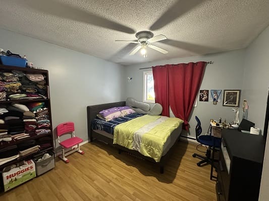 Bedroom with bed, closet, and desk.