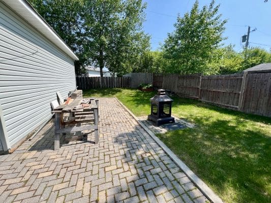 Backyard with patio, table, and fire pit.