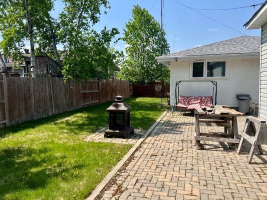 Backyard with patio, swing, and fire pit.