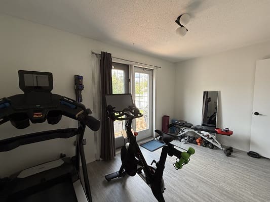 Home gym with exercise equipment and mirror.