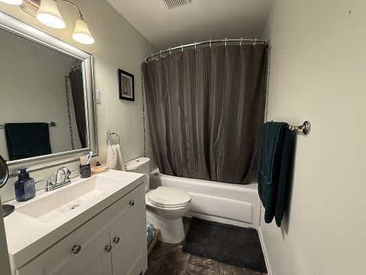 Small bathroom with tub and vanity sink.