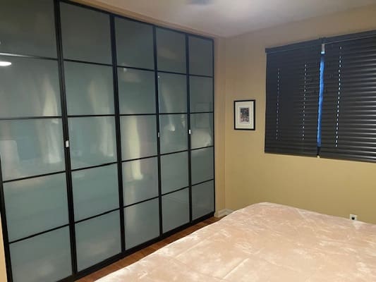 Bedroom with frosted glass closet doors.