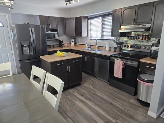 Modern kitchen with dark cabinets and appliances.