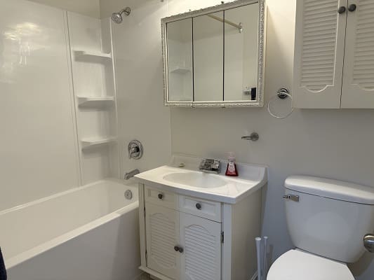 Small white bathroom with sink and bathtub.