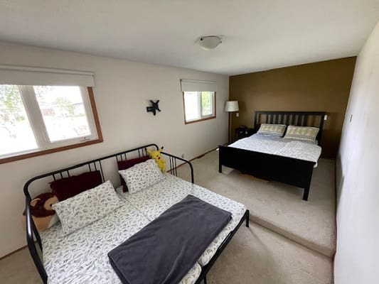 Bedroom with two beds and windows.