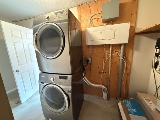 Stacked washer and dryer in laundry room.