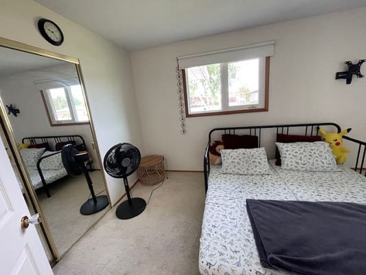 Bedroom with bed, fan, and window.