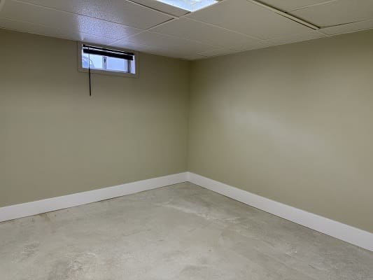 Empty room with small window and beige walls.