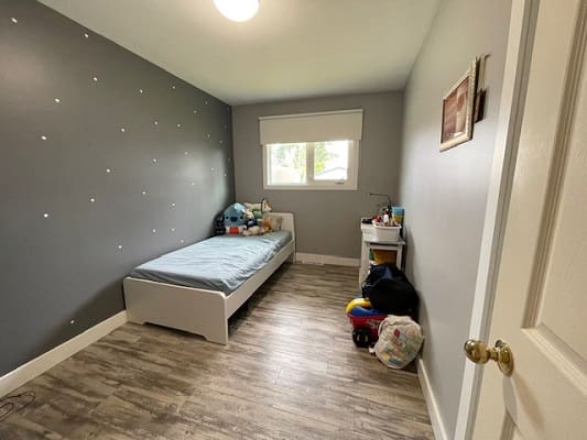 Child's bedroom with bed and toys.