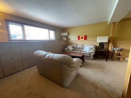 Basement living room with beige furniture.