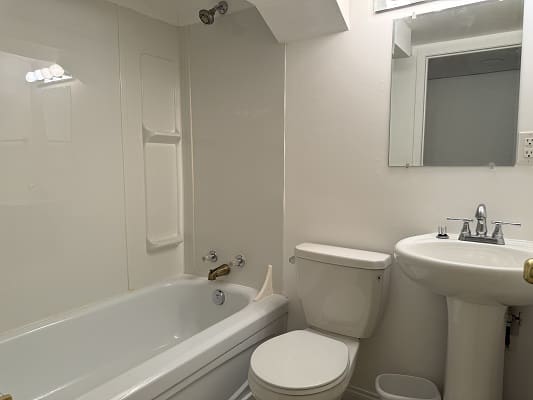 White bathroom with bathtub and pedestal sink.