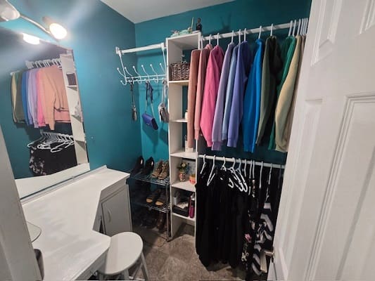 Organized closet with colorful clothes and shoes.