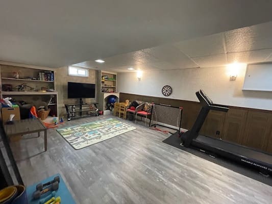 Basement playroom with treadmill and toys.