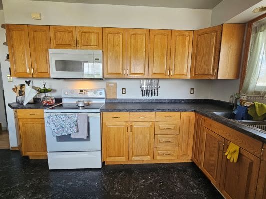 Wooden kitchen cabinets with black countertop.