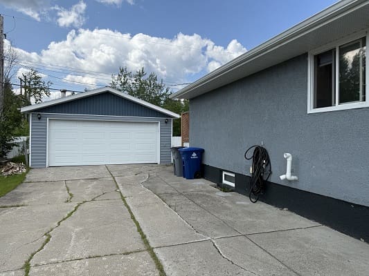 House driveway with garage and recycling bins.