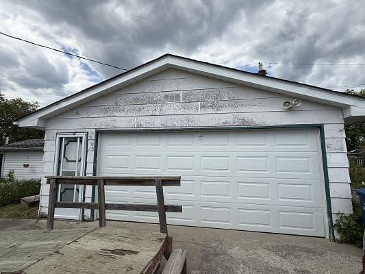 White garage with closed double doors.