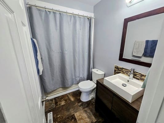 Small bathroom with shower and sink.