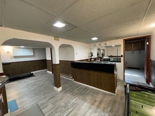 Basement with bar and exercise area.