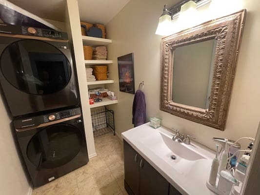 Laundry room with sink and storage shelves.