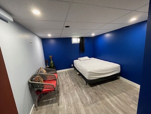 Simple room with bed and chairs.