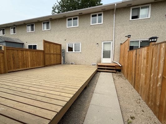 Backyard with wooden deck and fences.