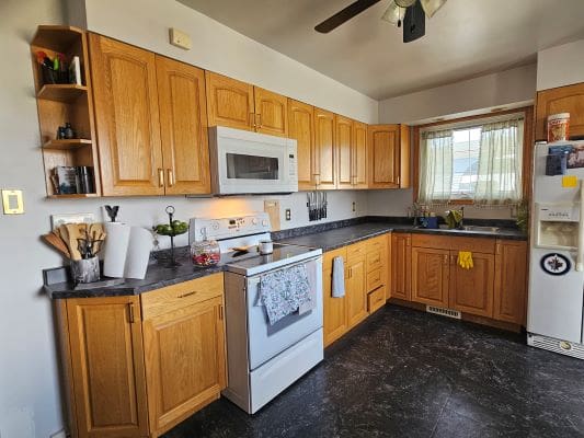 Home kitchen with wooden cabinets and appliances.