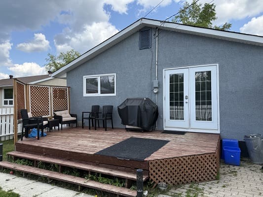 Backyard patio with chairs and grill.