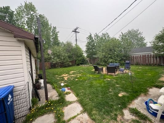 Backyard with patio chairs and greenery.