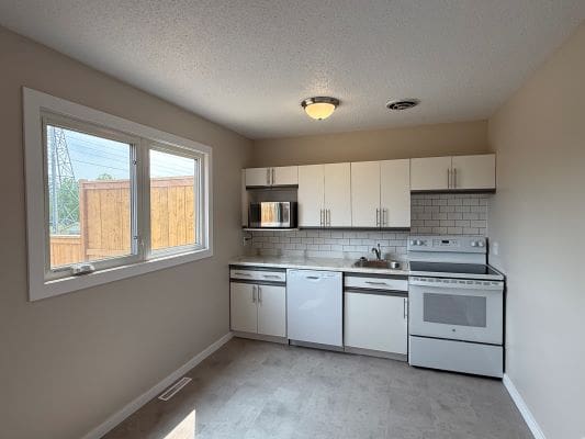 Small kitchen with appliances and large window.