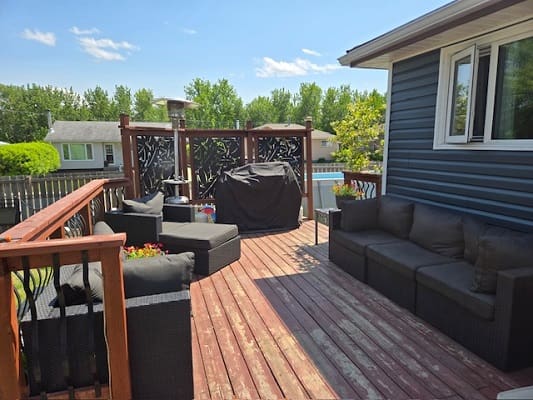 Outdoor deck with seating and barbecue grill.
