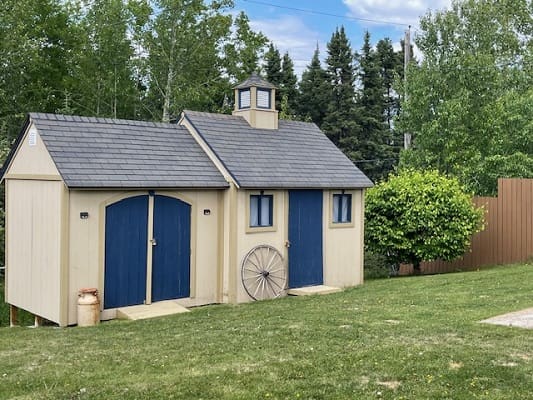 Small beige shed with blue doors.
