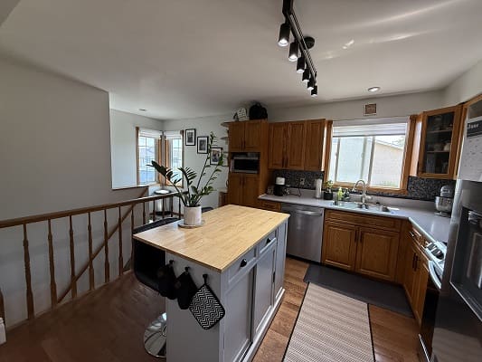 Modern kitchen with island and wooden cabinets.