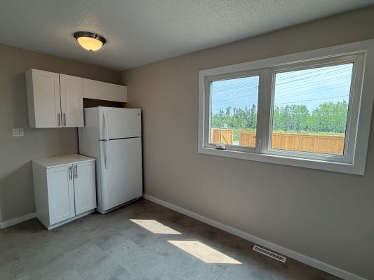 Small kitchen with window and white cabinets.