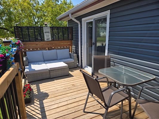 Outdoor deck with seating and glass table.