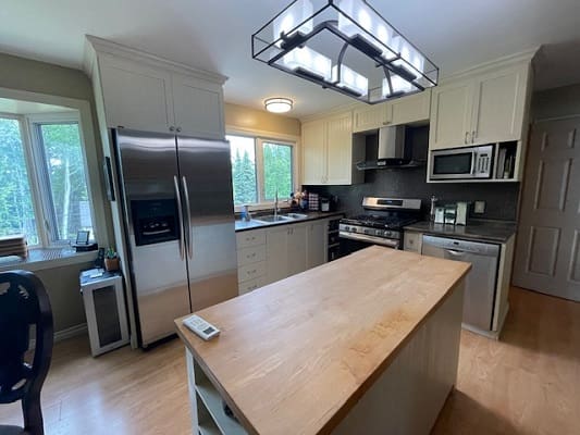 Modern kitchen with island and stainless appliances.