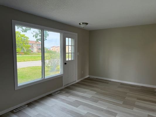 Empty room with large window and door.