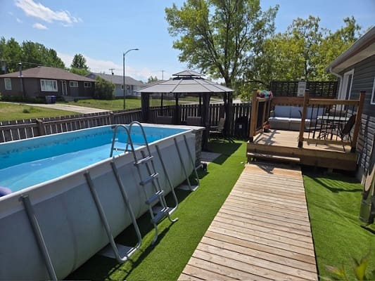 Backyard with pool and wooden deck.